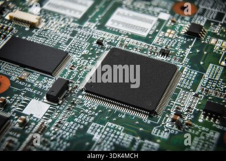 A close-up of a printed circuit board showing microchips, soldered components, and fine circuit traces, highlighting advanced electronics and modern h Stock Photo