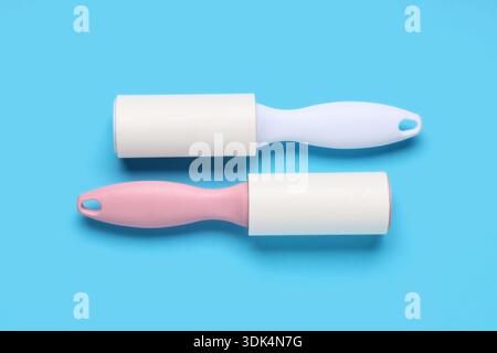 Sticky lint rollers on blue background Stock Photo