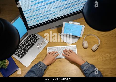 Programmer's hands working with computer keyboard and modern laptop on wooden background Stock Photo