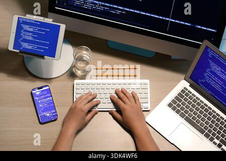 Male programmer working with computer keyboard and mobile phone on wooden background Stock Photo