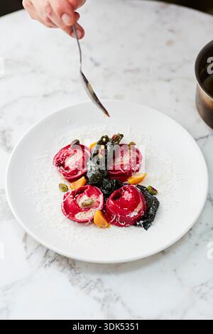 Beetroot ravioli with cavolo nero, pistachios and balsamic vinegar Stock Photo