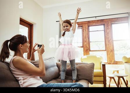 Recording, girl and mom with smartphone, home and child with costume for ballet rehearsal on website. Happy, woman and bonding with kid, memory and Stock Photo
