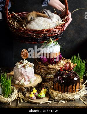 Warmly lit rustic setting with hand holding basket of Easter ornaments Stock Photo