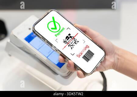 Hand holding smartphone showing QR code payment scanning near POS terminal. Cashless checkout concept for digital wallet, fintech banking, secure mobi Stock Photo