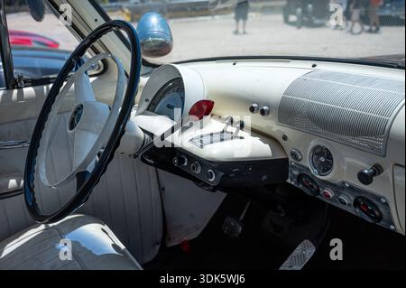 A detailed close-up of the pristine white interior of a classic 1953 Mercury Monterey, featuring the steering wheel, dashboard, and vintage controls. Stock Photo