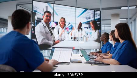 Healthcare Team Watching Educational Webinar On Hospital Conference Room Projector. Stock Photo