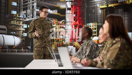 Young Aerospace Engineer Giving Presentation On Rocket Construction Techniques To Team Stock Photo