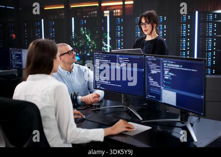 Multicultural Team Of Software Developers Coding Business Data On Computers Stock Photo