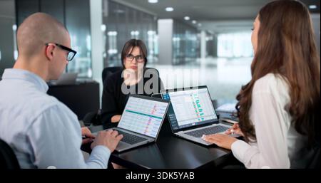 Busy Professionals Collaborating In Modern Office, Analyzing Data Report Together. Stock Photo