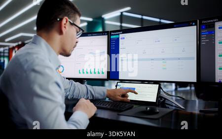 Busy Hispanic IT Specialist Multitasking On Small Desktop Computer Screen. Stock Photo