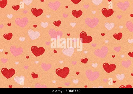 Red and pink hearts pattern on peach textured paper background for romantic design or Valentines Day. Stock Photo