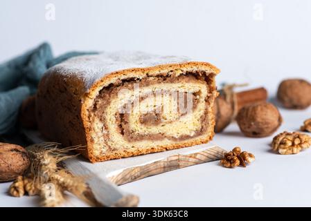 Freshly baked homemade strudel with walnuts or walnut bread roll, sprinkled with powdered sugar Stock Photo