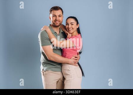 Embracing, standing and posing. Man and woman are in the studio. Stock Photo