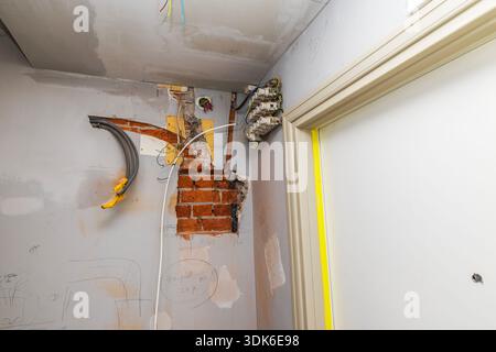 Close up view of exposed electrical wiring and brick wall during apartment renovation. Sweden. Stock Photo