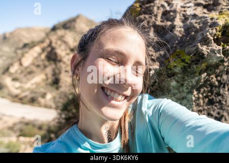 Young woman enjoying sunshine taking outdoor selfie Stock Photo
