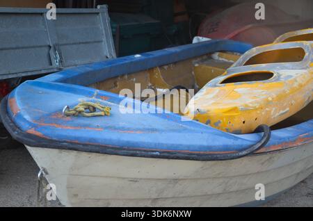 Blue and destroyed boat with yellow kayak on it Stock Photo