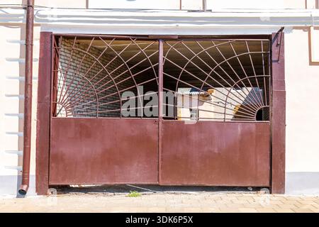 Closed entrance metal gates with bars of the stone city building Stock Photo