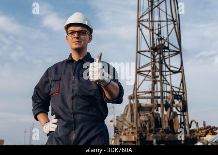 Thumb up gesture. Construction worker is near boring drilling machine. Stock Photo