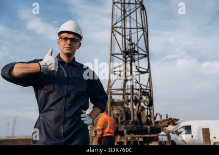 Thumb up gesture. Construction worker is near boring drilling machine. Stock Photo