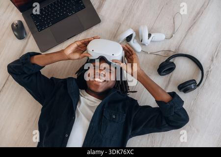 Top view of man that is lying down on floor in virtual reality headset. Stock Photo