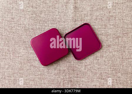 Burgundy metal box mock-up on textile pattern background. Top view. Stock Photo