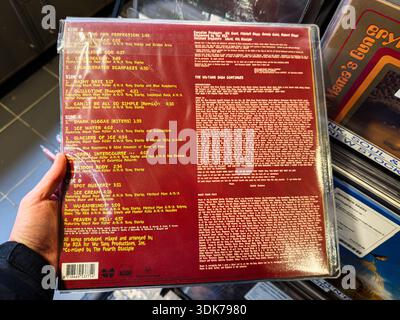 Manchester, UK - January 21, 2026: Vinyl back cover showing tracklist and credits for a hip hop album, with red maroon sleeve and dense text. Chef Rae Stock Photo