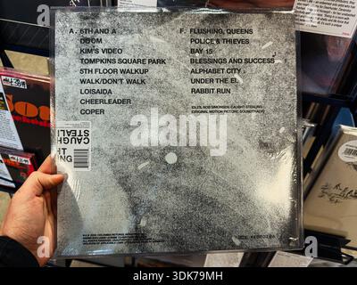 Manchester, UK - January 21, 2026: Close up of a vinyl back cover showing track list and a grainy, vintage design in a music store. Idles Caught Steal Stock Photo