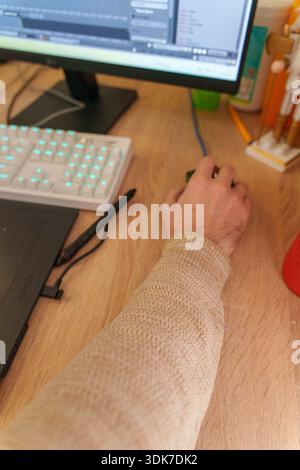 Person working on 3D animation at desk with graphics tablet and mechanical keyboard Stock Photo