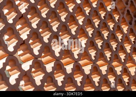 Decorative wall made of patterned hollow terracotta bricks, designed as a screen or partition allowing natural ventilation and light while providing s Stock Photo