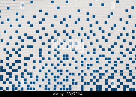 A full-frame, close-up photograph of a modern mosaic tile wall or floor with a random, pixelated pattern of small white and blue square tiles. This ge Stock Photo