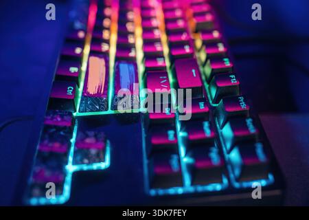 Colorful keyboard. Gaming computer is in the dark room with neon lighting. Stock Photo