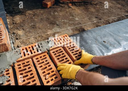 Close up view of construction man that is working with bricks. Stock Photo