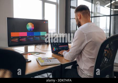 Working by using laptop. Designer is in the office. Stock Photo