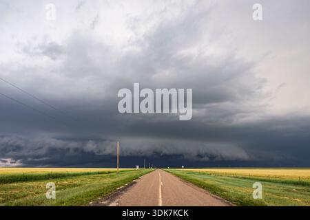 Developing Supercell storm on the horizon, black clouds at the end of a highway. Stock Photo