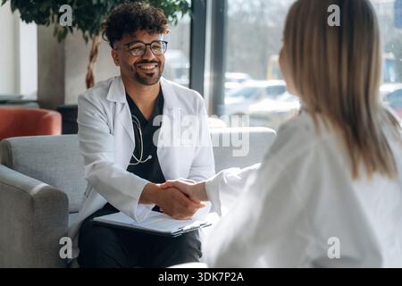 Consultation with doctor. Man and woman are indoors in modern building. Stock Photo