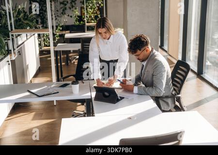 Project plan, working. Man and woman are indoors in modern building. Stock Photo