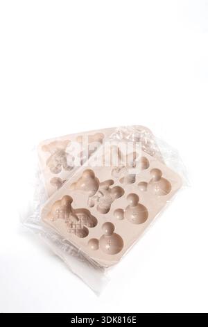 Two silicone baking molds in packaging on white background at angle. Stock Photo