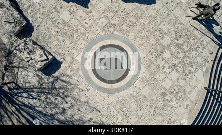 Aerial view of Nebraska state emblem on a patterned stone surface with shadows dancing across, Omaha, Nebraska, United States. Stock Photo