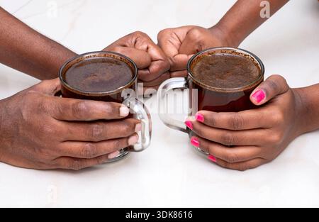 Two hands holding coffee cups, symbolizing warmth, connection, and shared moments. Stock Photo