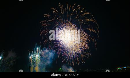 View of vibrant fireworks explode in the night sky, painting streaks of gold, white and blue against the dark canvas, Dallas, Texas, United States. Stock Photo