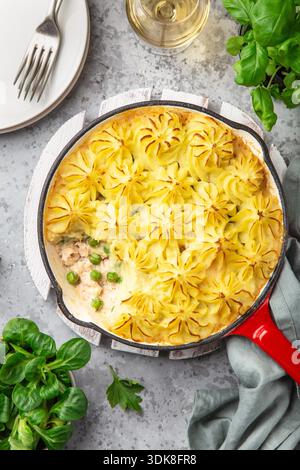 salmon shepherd's pie. Fish in creamy sauce , mashed potatoes and vegetables casserole in enamel cast iron pan. Top view Stock Photo
