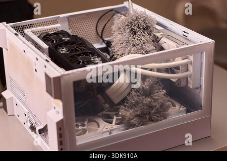 Cleaning computer components with brush. Closeup of dusty electronics being cleaned. Detailed shot of technician cleaning dust from motherboard and Stock Photo