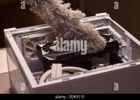 Cleaning computer components with brush. Closeup of dusty electronics being cleaned. Detailed shot of technician cleaning dust from motherboard and Stock Photo