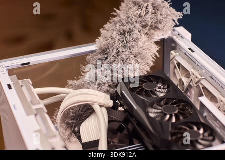 Cleaning computer components with brush. Closeup of dusty electronics being cleaned. Detailed shot of technician cleaning dust from motherboard and Stock Photo