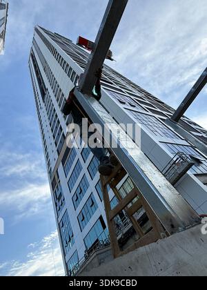 Construction worker on a ladder welding steel beams at a high-rise ...