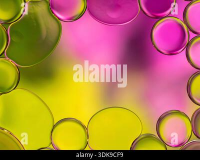 Colorful close-up of oil bubbles forming a vivid abstract frame. Bright pink, lime green, and sunny yellow create a lively, playful mood, perfect for Stock Photo