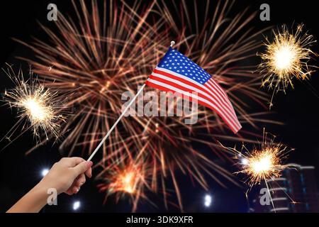Woman with american flag enjoying bursting fireworks in city, closeup. Celebrating national holiday Stock Photo