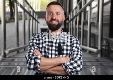 Man with hidden spy camera in his pocket on staircase outdoors Stock Photo