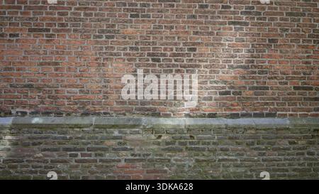 Defocused blurred image of a brick wall with natural bokeh effect, showcasing textured and rustic elements in an outdoor urban environment. Stock Photo