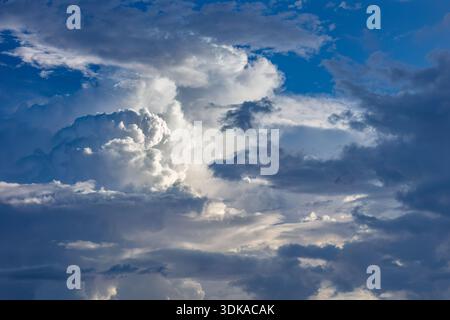 Dramatic dark and stormy cumulus clouds with blue sky in the background. Possibly cumulus congestus  or cumulonimbus. During summer thunderstorm seaso Stock Photo